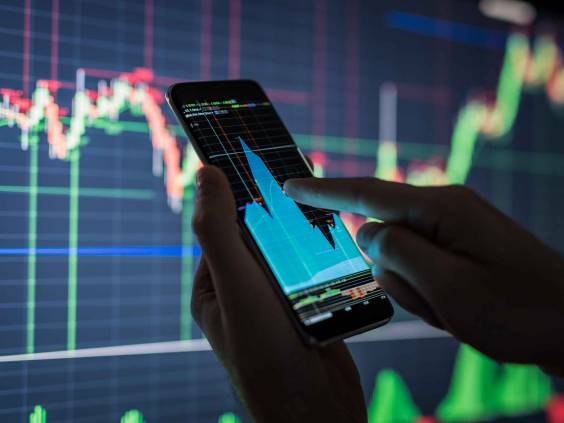 Businessman checking stock market data. He using a mobile phone. Analysis economy data on forex earn graph.
