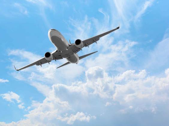 White passenger airplane over the clouds - Travel by air transport