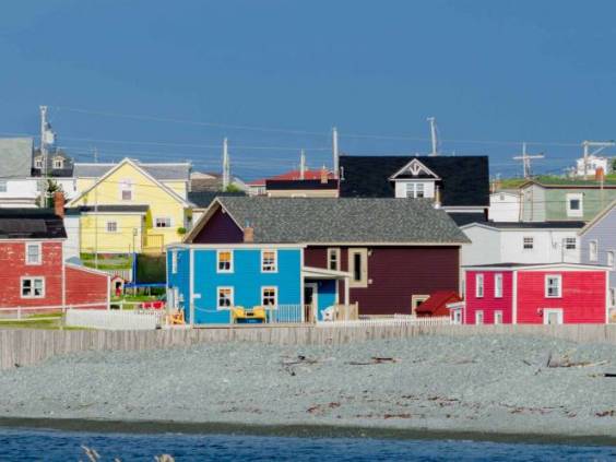 Small town with bright colored homes all over the coastal villages along the fingers of the Island of Newfoundland, Canada.