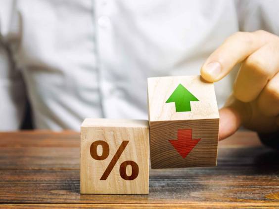 Businessman holds wooden blocks with percent and up or down arrow. Mortgage and loan rates. Interest rate, stocks, ranking. Business and finance concept.