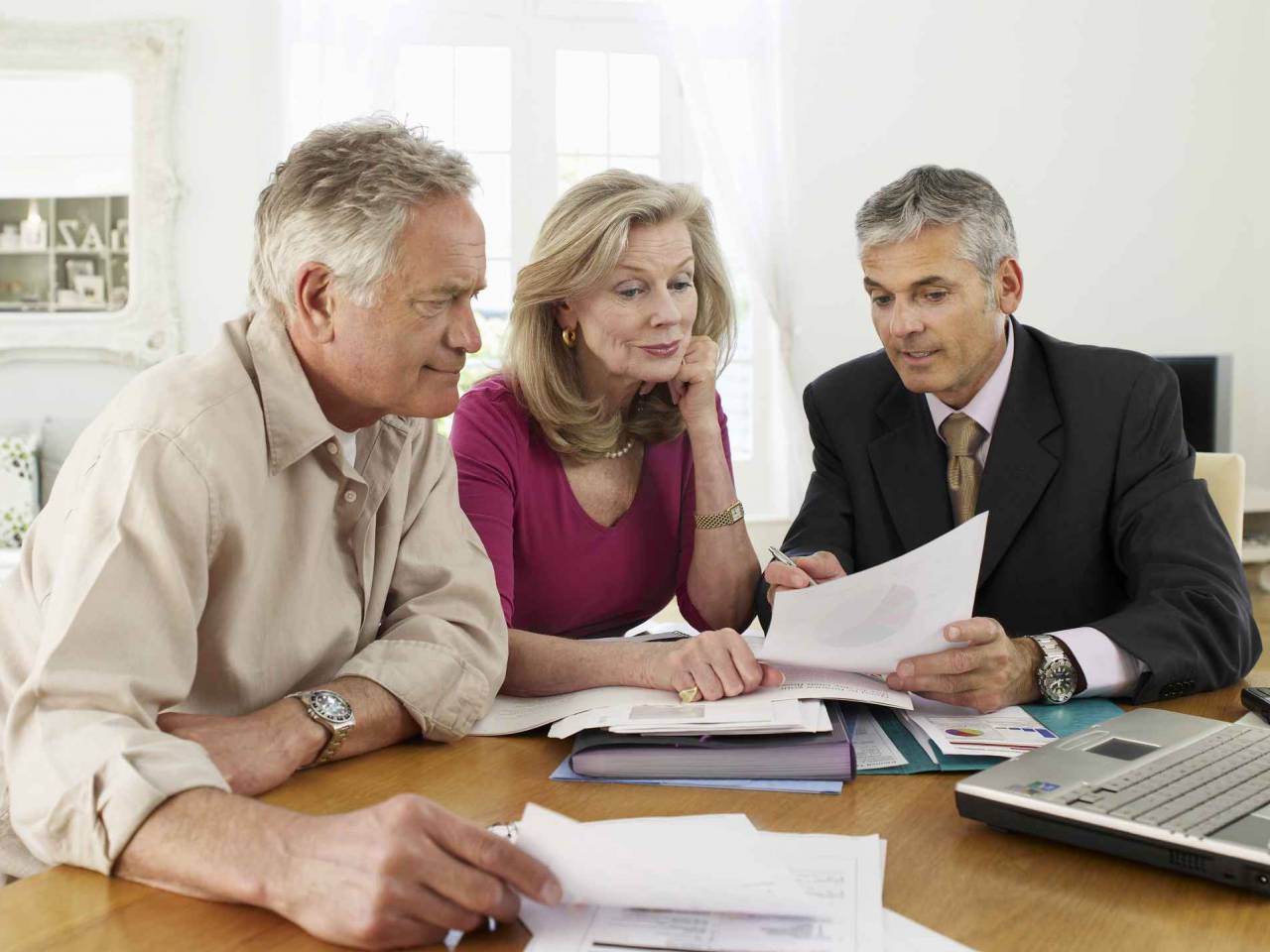 Mature couple sitting at table with financial advisor