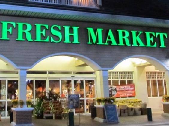 Storefront of the Fresh Market store at night.