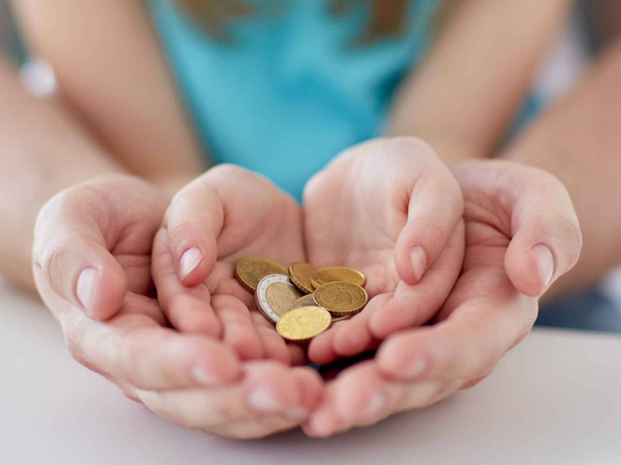 family, children, money, investments and people concept - close up of father and daughter hands holding euro money coins