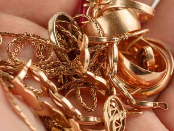 Pile of gold jewellery in hand, closeup shot