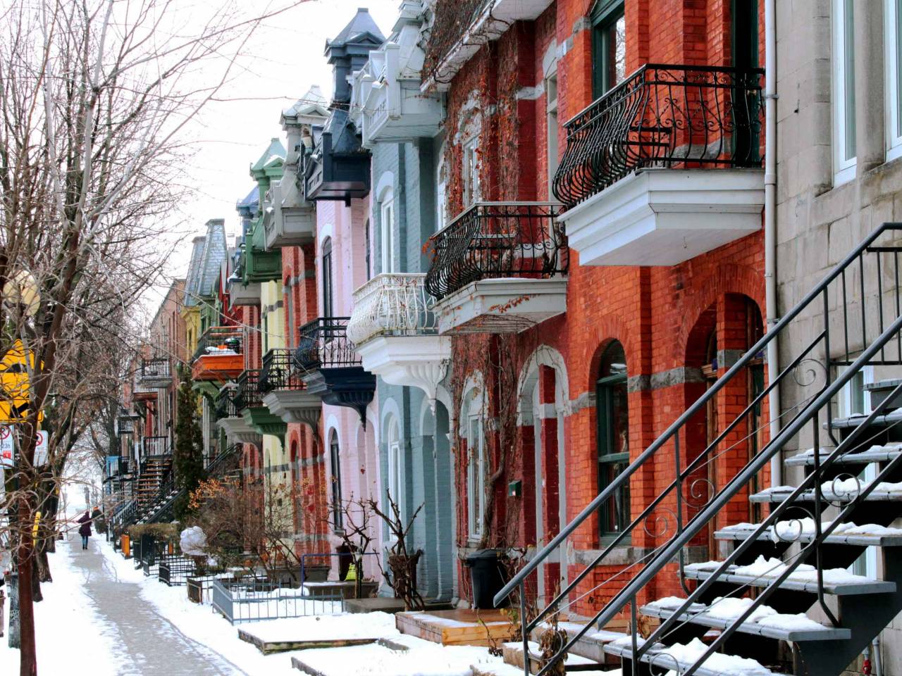 Beautiful houses of old historical Montreal neighborhood Plateau Mont Royal in winter season, bright painted doors.