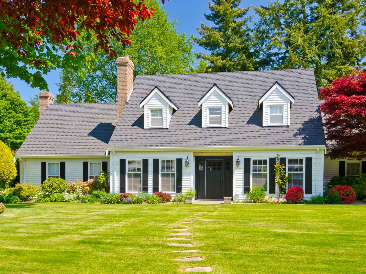 Custom built luxury house with nicely trimmed and landscaped front yard, lawn in a residential neighborhood. Vancouver Canada.