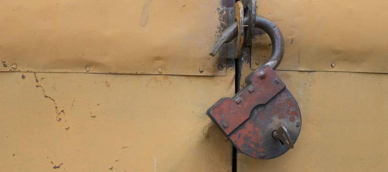 The old hinged granary rusty lock on orange doors