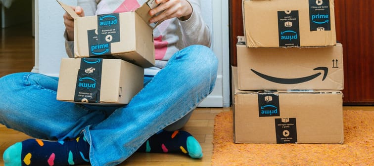 Woman sitting on ground opening Amazon packages