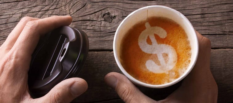 Expensive black coffee take-out. Business for sale of coffee. The man is holding a mug of coffee with foam in the form of a dollar sign.