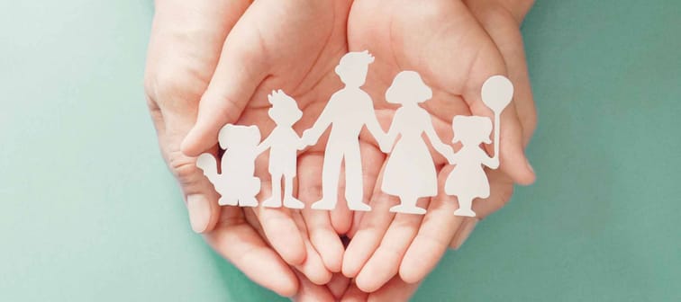 Adult and children hands holding paper family cutout, life insurance planning, adoption, foster care, homeless support, family mental health, family wellness, social distancing concept