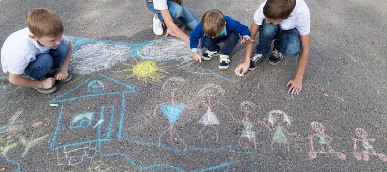 Children draw their large blended family on the street with chalk