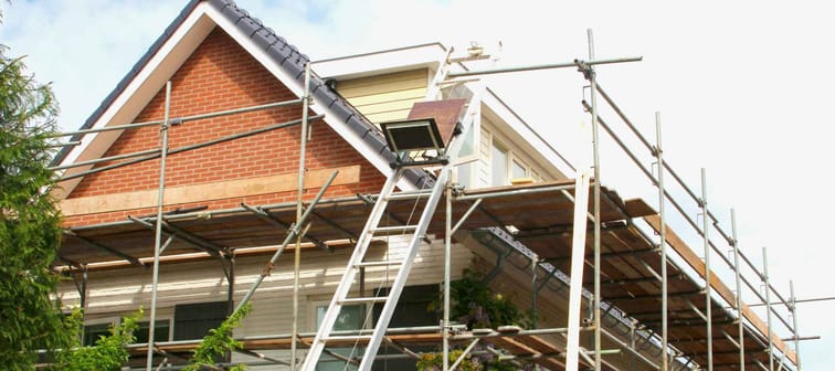 Outside renovation of modern residential house, scaffolding tower
