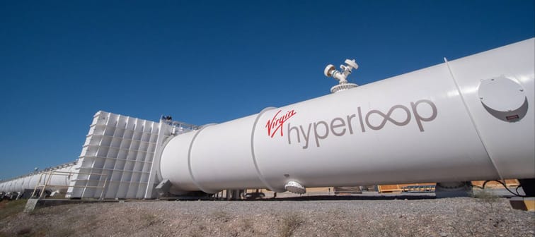 A long, big tube that says Virgin Hyperloop on the side at a test site