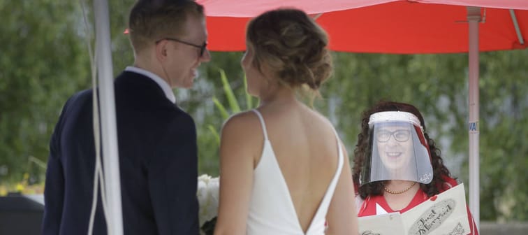 A couple gets married in a Vancouver at a micro wedding during the pandemic, with the officiant wearing a face shied