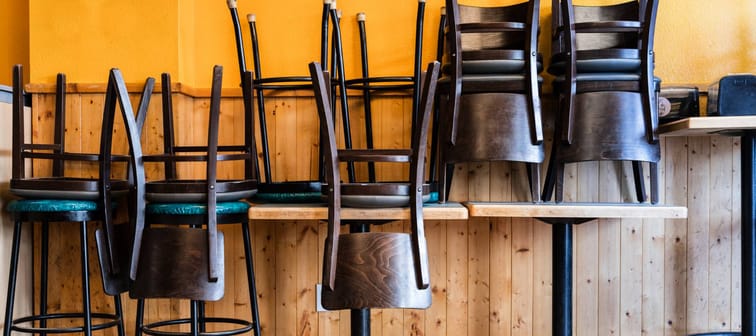 Chairs and Stools Stacked on Tables in an Empty Closed Restaurant during Covid-19 Pandemic