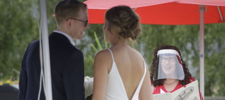 A couple gets married in a Vancouver at a micro wedding during the pandemic, with the officiant wearing a face shied