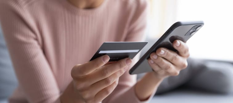 Close up female hands holding credit card and smartphone