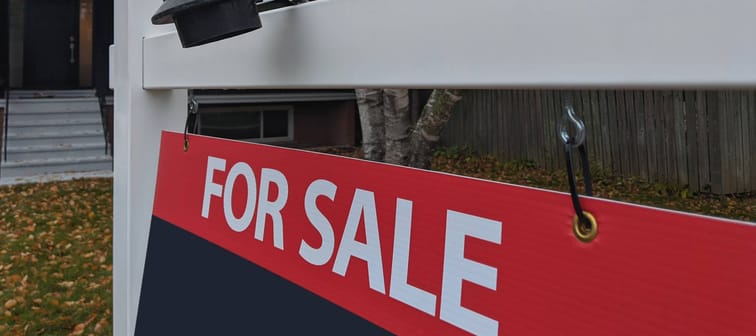 Fresh new sign sold over asking for sale in front of detached house in residential area.