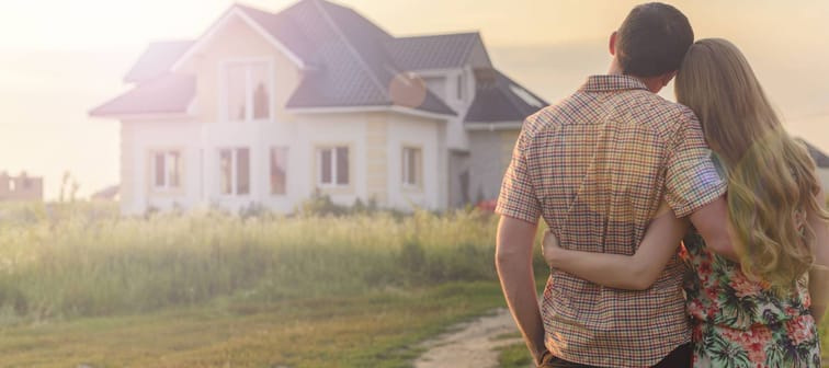 rear view of young couple looking at their new house