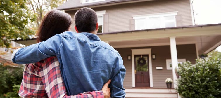 Rear View Of Loving Couple Looking At House