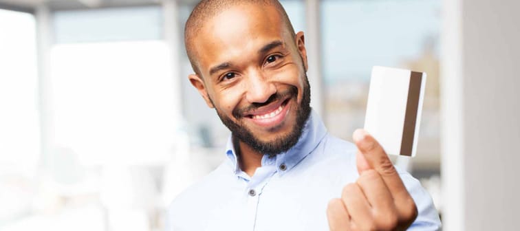 Man smiles with credit card